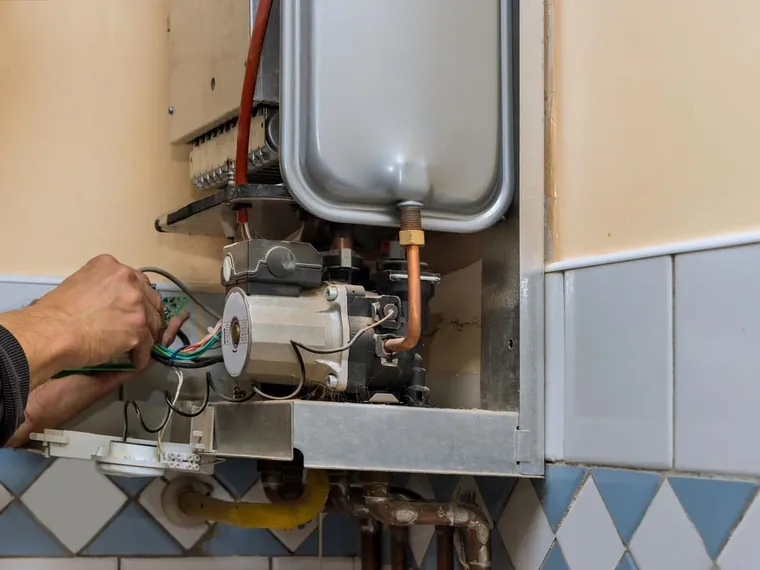 Gásfiter reparando un calefón a domicilio en Santiago